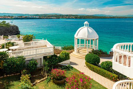 Beautiful white gazebo and tropical flower garden on Caribbean ocean background, summer mountain view , Sosua, Puerto Plata, Dominican Republicの写真素材