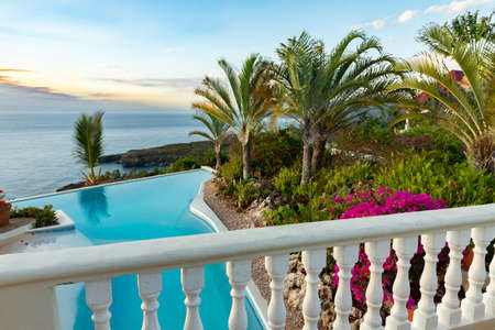Stunning ocean view from a victorian terrace, pool, and tropical garden with bougainvillea in bloom, copy spaceの写真素材