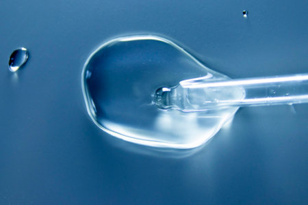 Drops from a pipette. Liquid gel or serum on a microscope screen on a white backgroundの写真素材