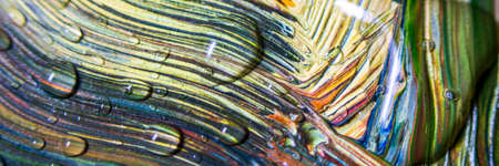 Banner Colorful multicolored paint covered with water drops, theme wallpaper background. Multicolor...