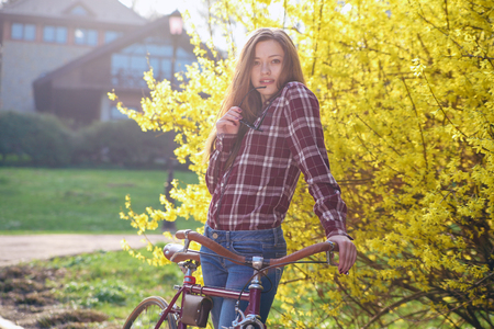 Beautiful young woman with vintage bicycle in a parkの写真素材