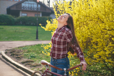 Beautiful young woman with vintage bicycle in a parkの写真素材