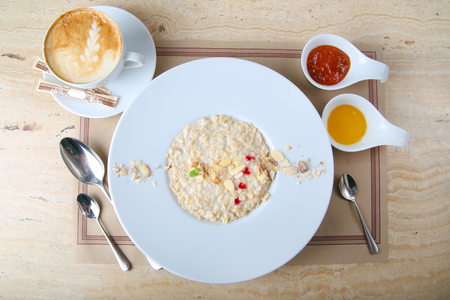 Breakfast: Oatmeal porridge in a bowl topped with fresh red-berries, cranberriesの写真素材