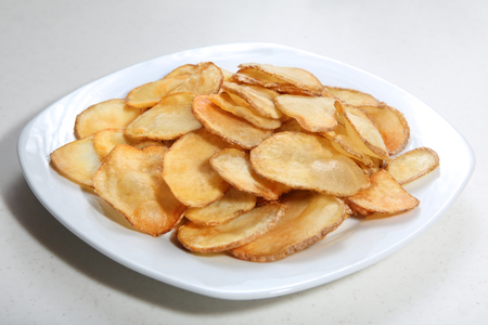 Potato chips isolated on white plateの写真素材