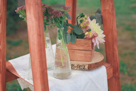 Rustic wedding photo zone. Hand made wedding decorations includes Photo Booth, wooden barrels and boxes, lanterns, suitcases and white flowersの写真素材