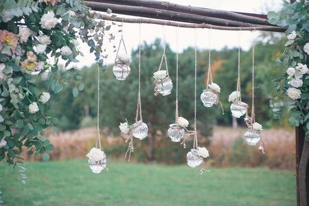 Original wedding floral decoration in the form of mini-vases and bouquets of flowers hanging from the ceilingの写真素材