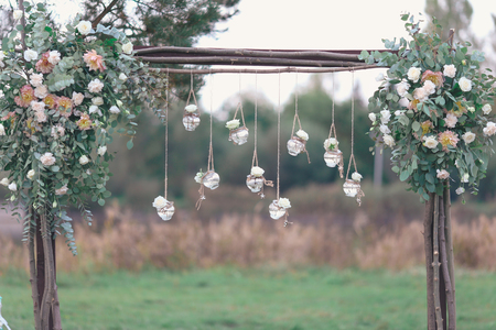 Rustic wedding photo zone. Hand made wedding decorations includes Photo Booth, wooden barrels and boxes, lanterns, suitcases and white flowersの写真素材