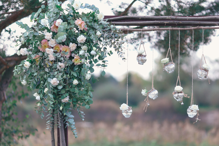 Rustic wedding photo zone. Hand made wedding decorations includes Photo Booth, wooden barrels and boxes, lanterns, suitcases and white flowersの写真素材