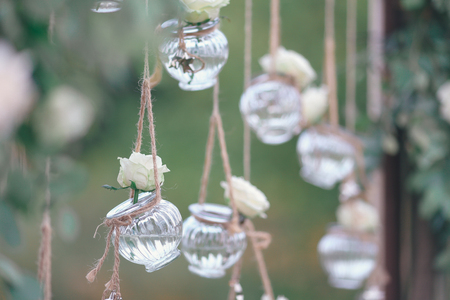 Original wedding floral decoration in the form of mini-vases and bouquets of flowers hanging from the ceilingの写真素材