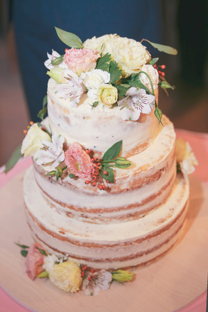 Beautiful wedding cake with cream and flowersの写真素材