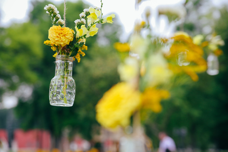 Original wedding floral decoration in the form of mini-vases and bouquets of flowers hanging from the ceilingの写真素材