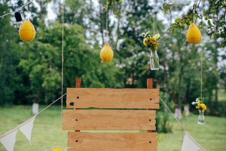 Green wood yellow flowers photo zone with rustic decorationsの写真素材