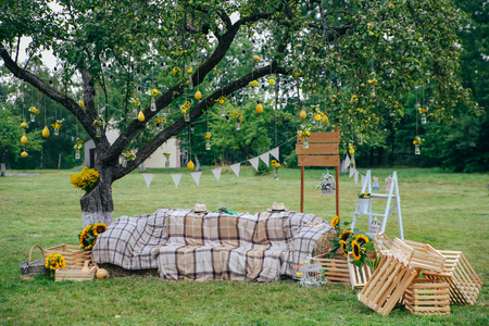 Rustic wedding photo zone. Hand made wedding decorations includes Photo Booth, wooden barrels and boxes, lanterns, suitcases and white flowersの写真素材