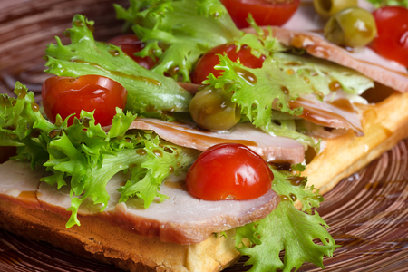Plate of belgian waffles with ham, tomatoes, herbs and balsamic vinegarの写真素材