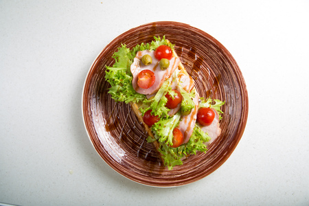 Plate of belgian waffles with ham, tomatoes, herbs and balsamic vinegarの写真素材
