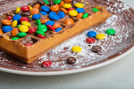 Plate of belgian waffles with colored candyの写真素材