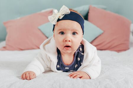 Adorable two month old baby girl lying on the pillow and looking into the cameraの写真素材