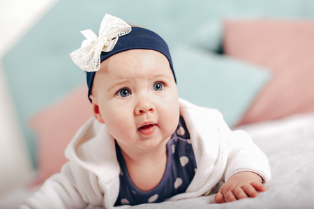 Adorable two month old baby girl lying on the pillow and looking into the cameraの写真素材
