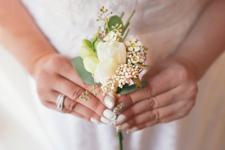 Beautiful bride is holding a wedding colorful bouquet. Beauty of colored flowers. Close-up bunch of...