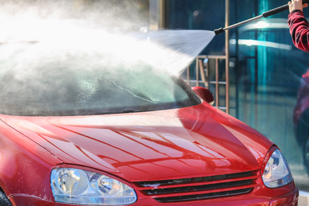 Man cleaning car using high-pressure waterの写真素材