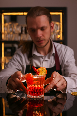 Professional bartender prepairing orange cocktailの写真素材