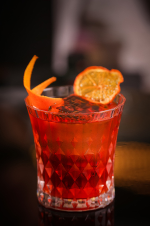 Orange cocktail in retro glass on black backgroundの写真素材