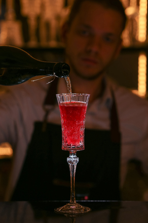 Kir Royal cocktail with orange slice and ice cubes.の写真素材