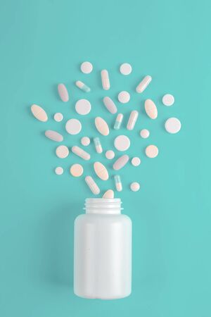 Assorted pharmaceutical medicine pills, tablets and bottle on blue background. Copy space for textの写真素材