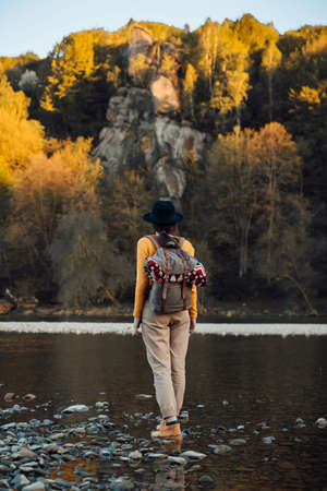 Young woman traveler stand with backpack on river nature backgroundの写真素材