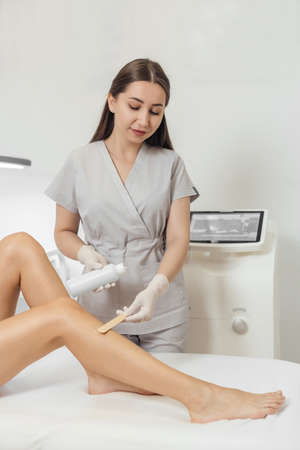 Beautician make a laser epilation and cosmetology procedureの写真素材
