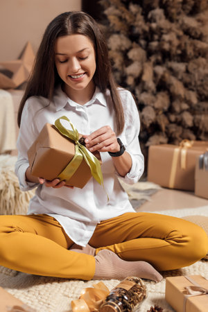 Young woman is wrapping christmas presents for holidaysの写真素材