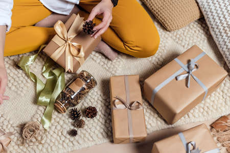 Young woman is wrapping christmas presents for holidaysの写真素材
