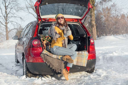 Woman with coffee paper car has winter car picnicの写真素材