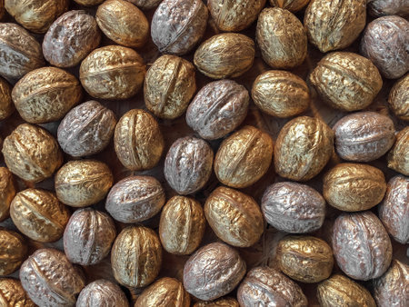 Autumn vibe background texture formed from gold and silver painted walnuts flat laid on tableの写真素材