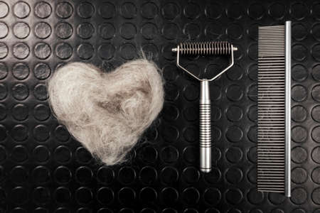 Bunch of dog hair after grooming in shape of heart on black background