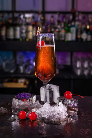 Fresh orange cocktail drink with cherry and ice cubes on black backgroundの写真素材
