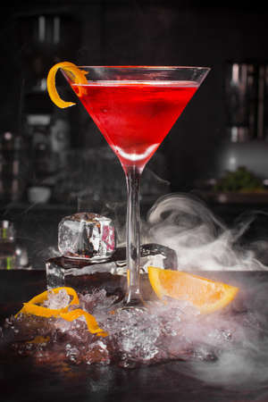 Cocktail drink with fruits and ice cubes on black backgroundの写真素材