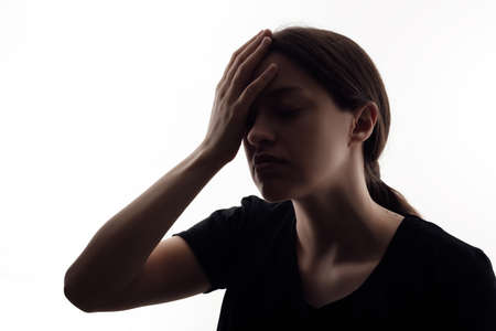 Silhouette of woman that has headache. Isolated portrait on white backgroundの写真素材