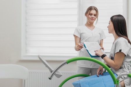 Gynecologist talking with a female patient during a medical consultation in the gynecological roomの写真素材