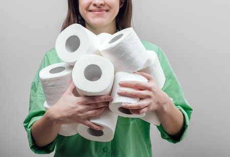 Young woman holds rolls of toilet paper by two hands