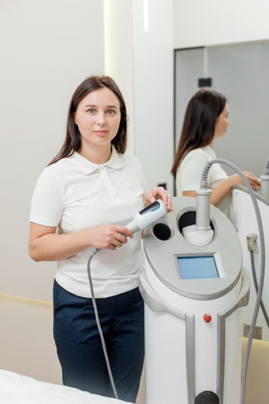 Cosmetologist woman portrait with endospheres device in hands in beauty salonの写真素材