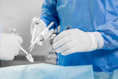 Doctor using ultrasonic surgery scissors during operation. Ultrasonic scalpel and scissor gripの写真素材