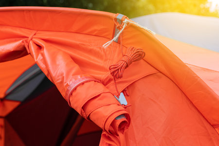 The fabric of the inner zone of the tent is twisted into a roll and fixed