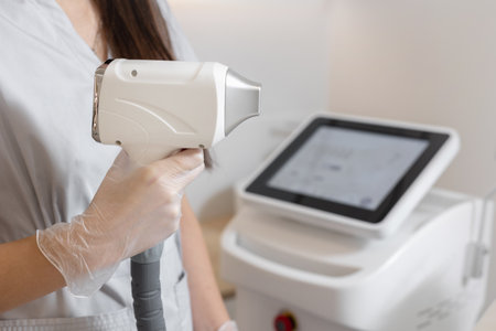 Cosmetologist hold in hand laser hair removal device