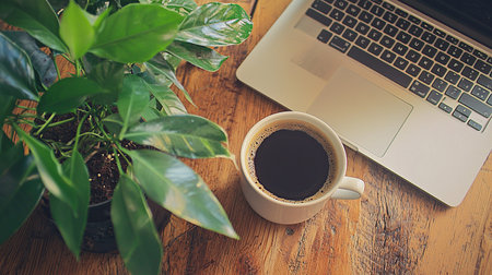Minimalist office with laptop, coffee, and plant on wooden desk for productive work