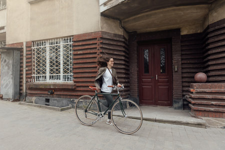 Retro cyclist in tweed clothes enjoying a ride down a charming urban streetの写真素材