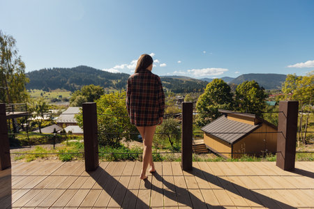 Woman enjoying a peaceful moment on a balcony overlooking natureの写真素材