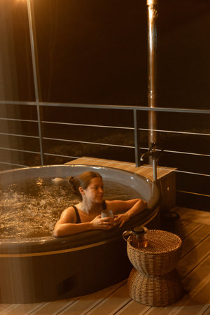 Relaxing evening in a hot tub on a balcony at nightの写真素材