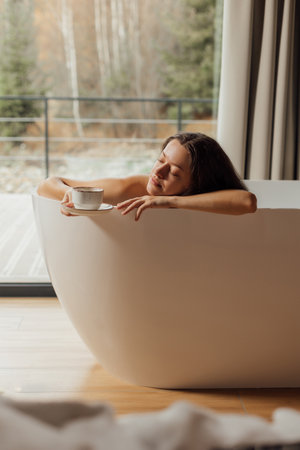 Woman relaxing in a modern bathtub in a peaceful settingの写真素材