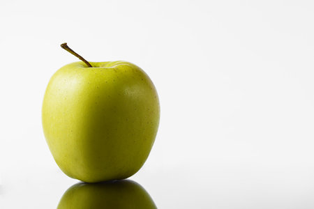 Green and yellow apple on a white background in a mirror imageの写真素材